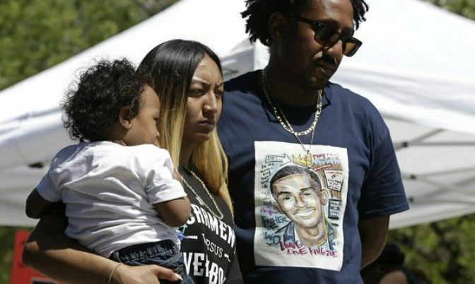 Stephon Clark’s fiancee Salena Manni, holds the couple's son, Aiden as she and Clark's uncle, Curtis Gordon attend a rally. (AP Photo/Rich Pedroncelli)